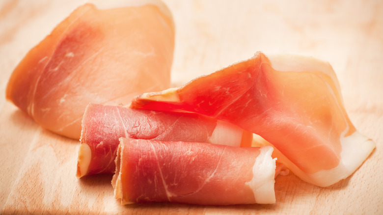 Prosciutto slices on cutting board