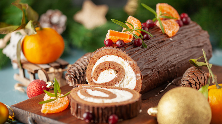 A yule log decorated with cherries and oranges.