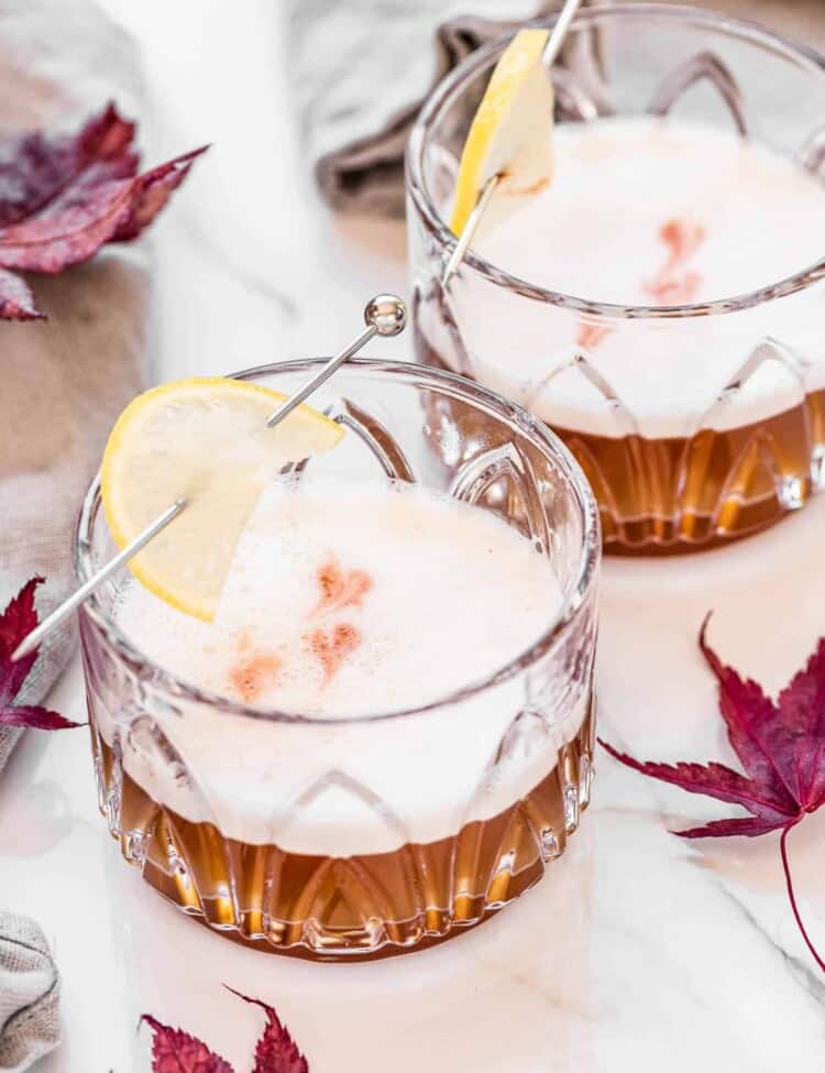 Two Maple Bourbon Sours surrounded by maple leaves