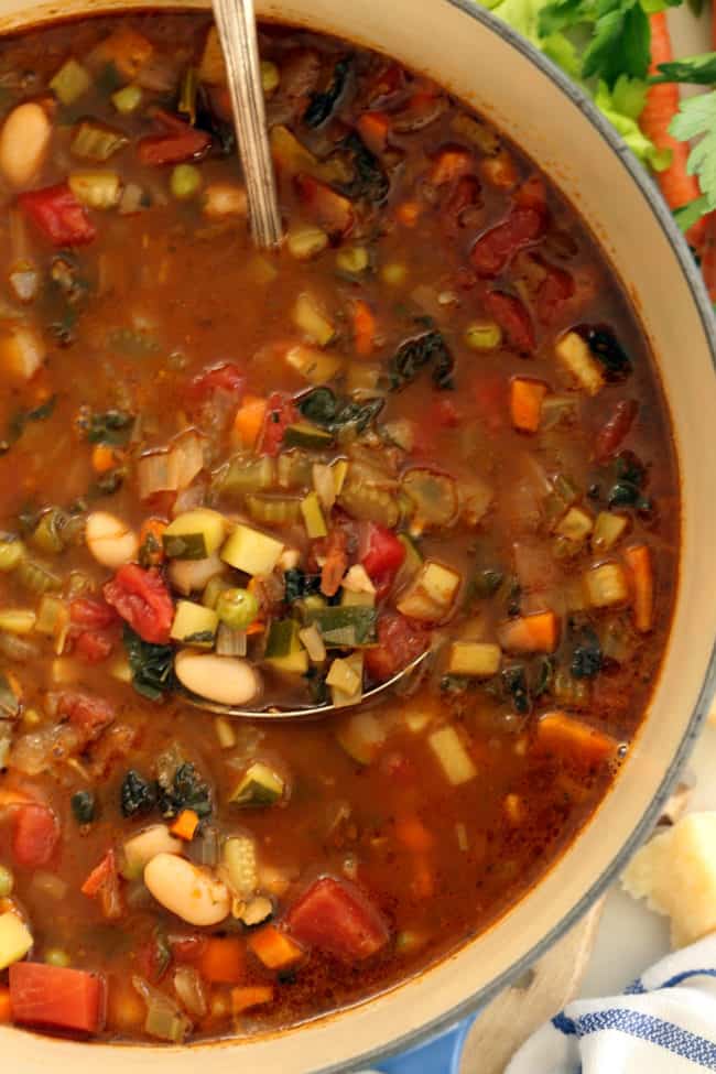 A pot of easy minestrone soup with a ladle in it.