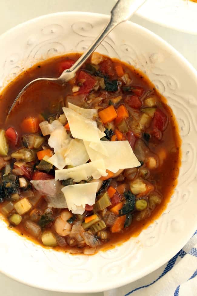 A white bowl filled with Minestrone Soup.