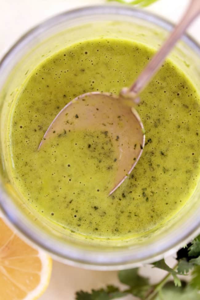 A clear glass mason jar of healthy homemade salad dressing.