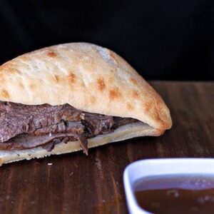 Beef Sandwich and Dip Sauce on Wood Background