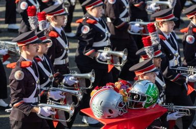 Members from the Ohio State University Marching Band walk past the football helmets of Ohio State and Oregon at the Rose Parade Wednesday in Pasadena. Credit: Sandra Fu | Photo Editor