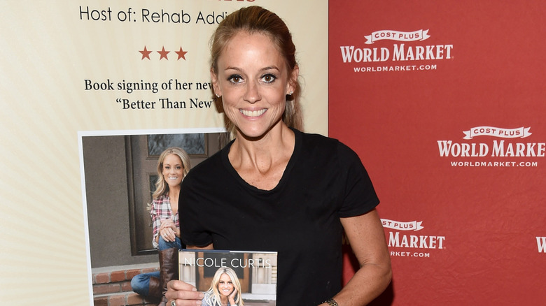 Nicole Curtis smiles for photos at a book signing