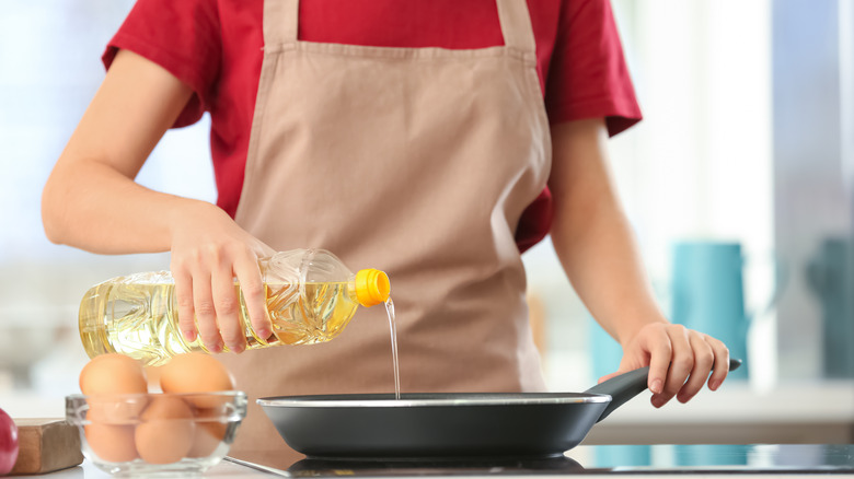 Woman cooking with oil