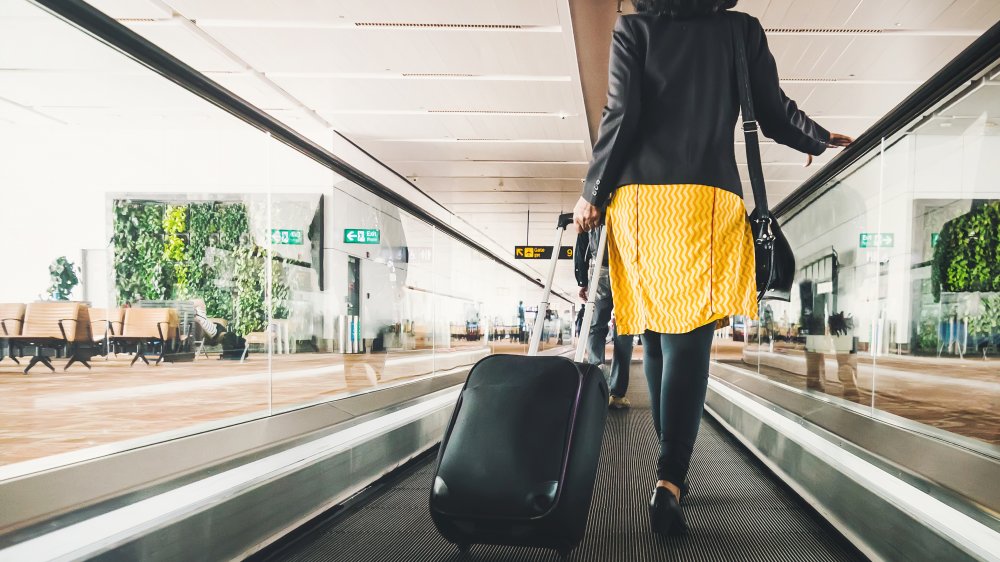 woman traveling in airport with luggage