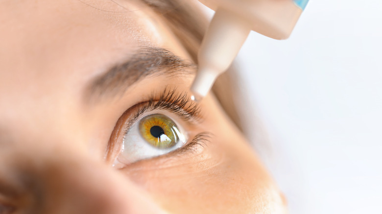 Close up picture of a woman putting drops in her eye