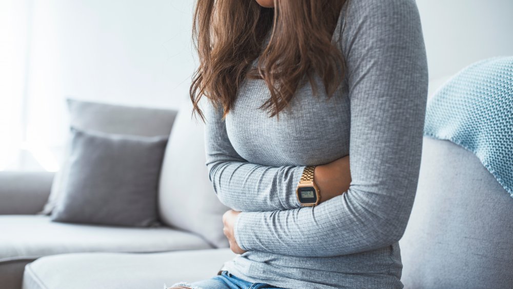 A woman struggling with stomach pain from spicy food