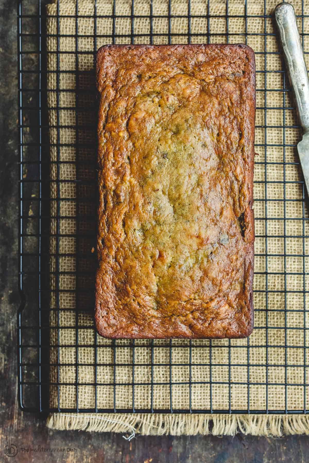 Whole loaf of banana walnut bread on wire rack