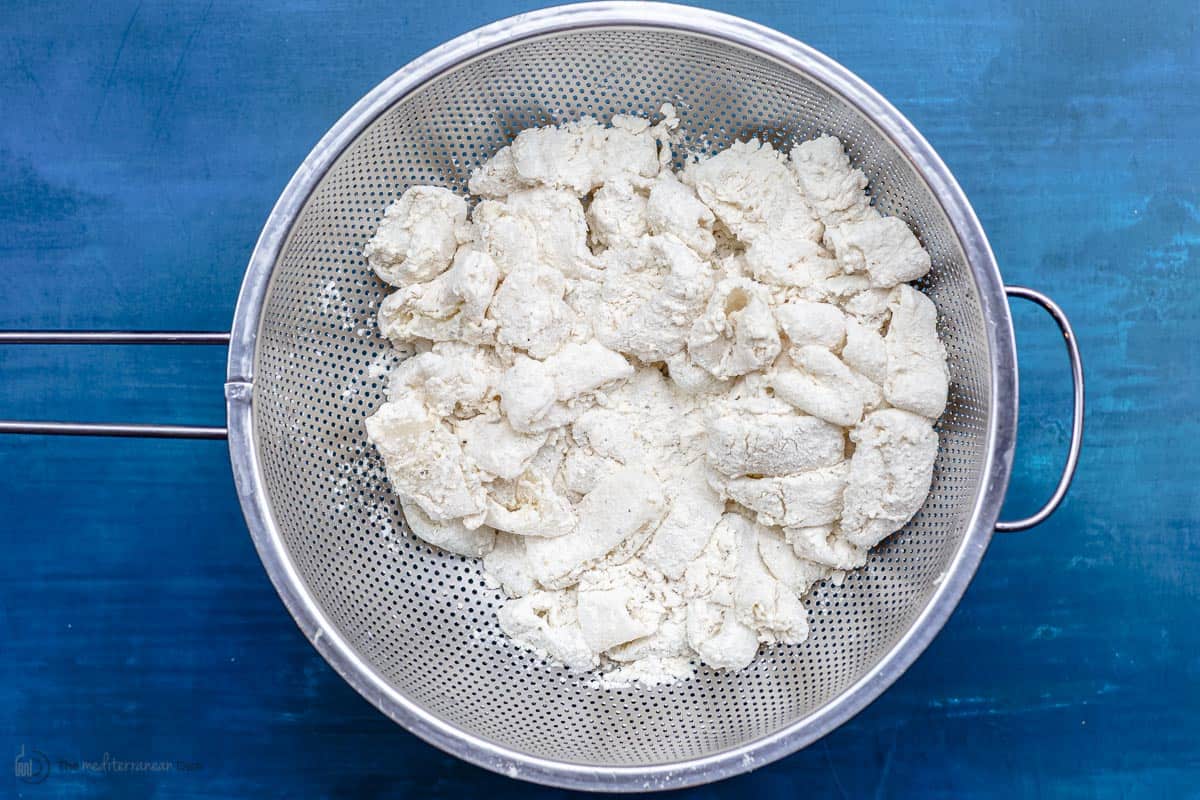 Calamari coated with batter and placed in a colander