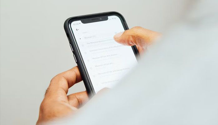 A mans hand is seen holding an iPhone while typing something. — Apple website/File