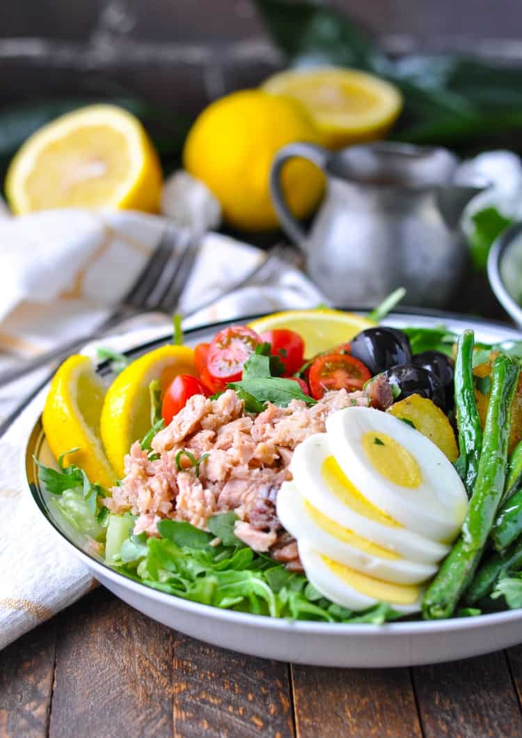 A side shot of a Tuna Nicoise Salad on a wooden surface