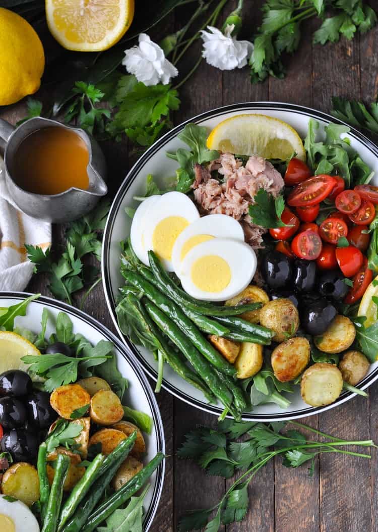 Close up overhead photo of a Tuna Nicoise Salad in bowls with homemade red wine vinaigrette dressing and tuna