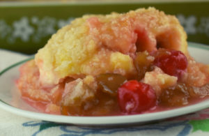 Cherry Rhubarb Crisp with sour cream is made in a 9x13 pan which serves a crowd.  Served alone or drizzle the rhubarb syrup over ice cream for an old fashioned dessert.  The addition of maraschino cherries in this rhubarb crisp makes it extra special.