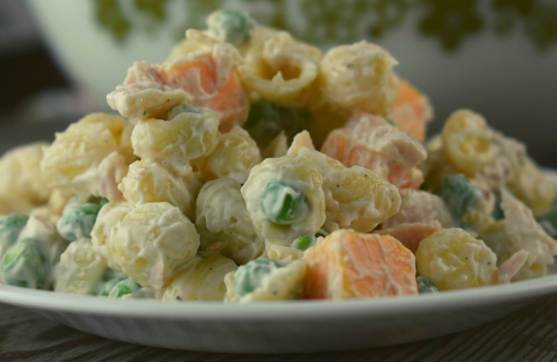 Tuna Pasta Salad is an Old Fashioned Macaroni Salad with Tuna that has frozen peas, albacore tuna and cheddar cheese cubes. It's simplicity can be deceiving since it packs a punch of flavor that is perfect for your summer dinner table. 