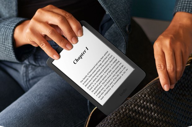 a woman is holding a kindle with chapter 1 on the screen