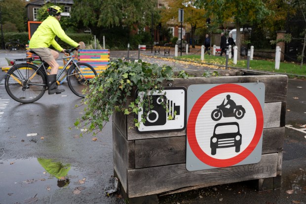 a person riding a bike next to a sign that says no motorcycles