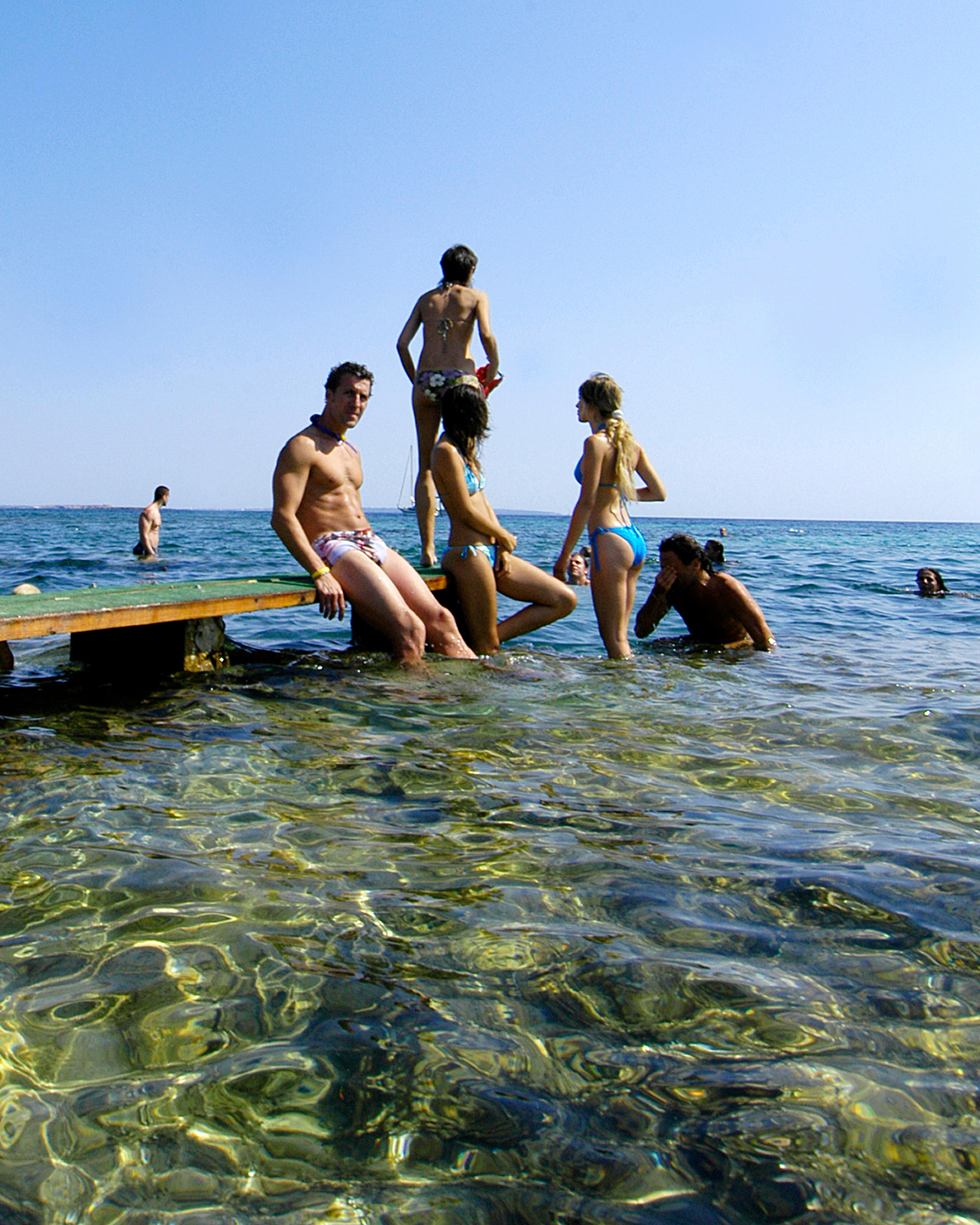 Young people taking a bath in Las Salinas beach, in Ibiza, Balearic Islands, Spain