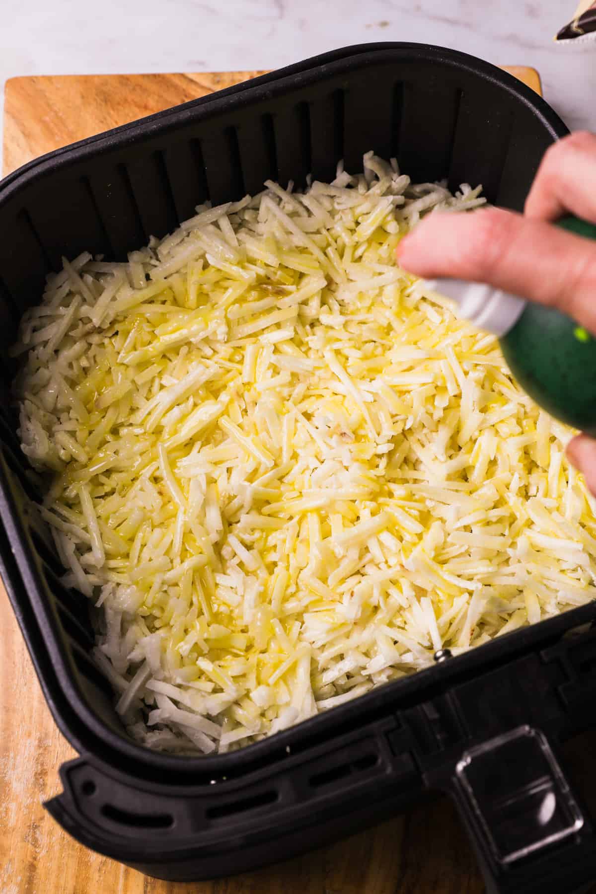 spraying hash browns with cooking spray