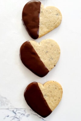 chocolate dipped heart cut out cookies on parchment