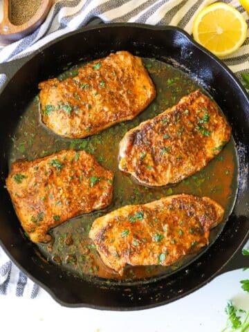 a large cast iron skillet with lemon pepper pork chops