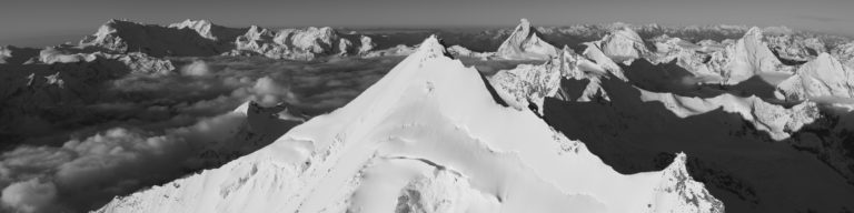 Photo panoramique noir et blanc d'une mer de nuage en montagne dans la vallée de Zermatt Val d'Anniviers