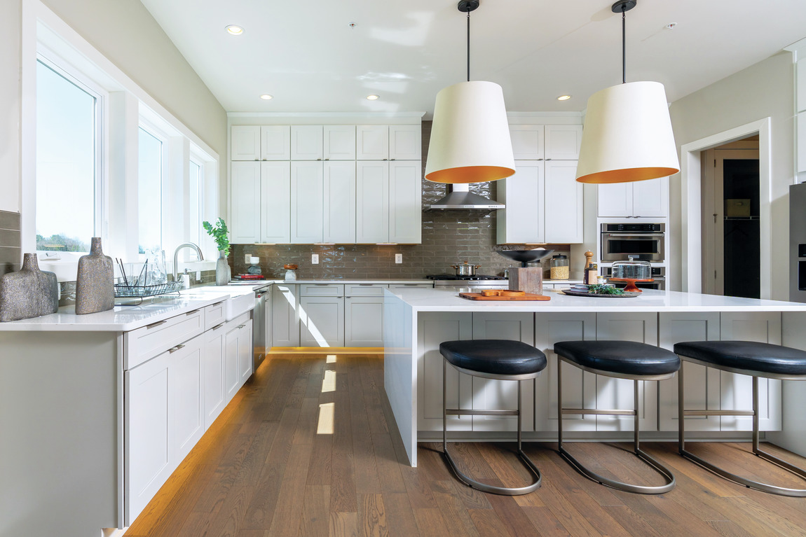 A large modern kitchen with luxury features such as a waterfall center island.