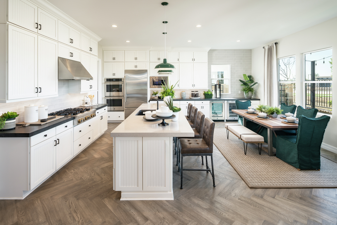 Kitchen featuring teal and green color scheme and large leather barstools.