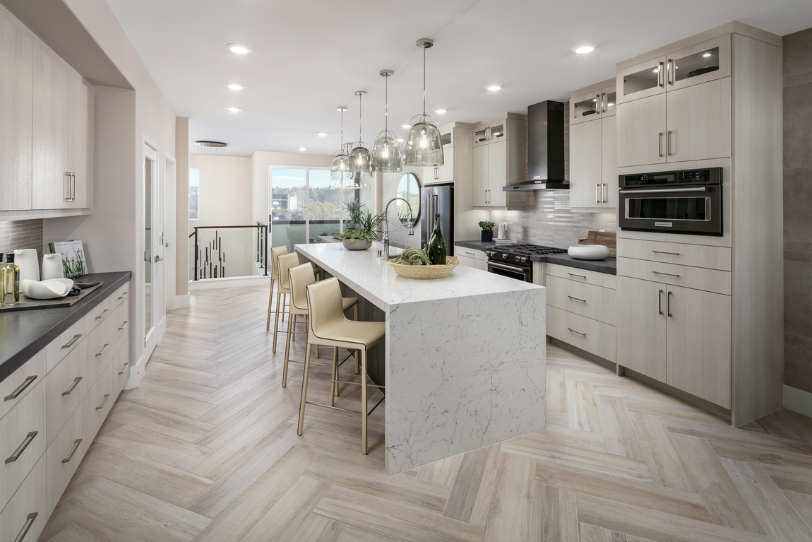 A modern kitchen design with coastal features a waterfall kitchen island.