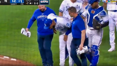 Amir Garrett bending over near trainers