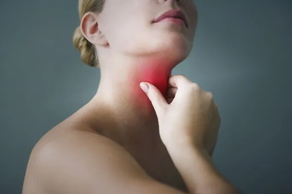 A woman with a red spot on her neck suggests a possible sore throat