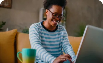 A woman smiling while using a laptop computer