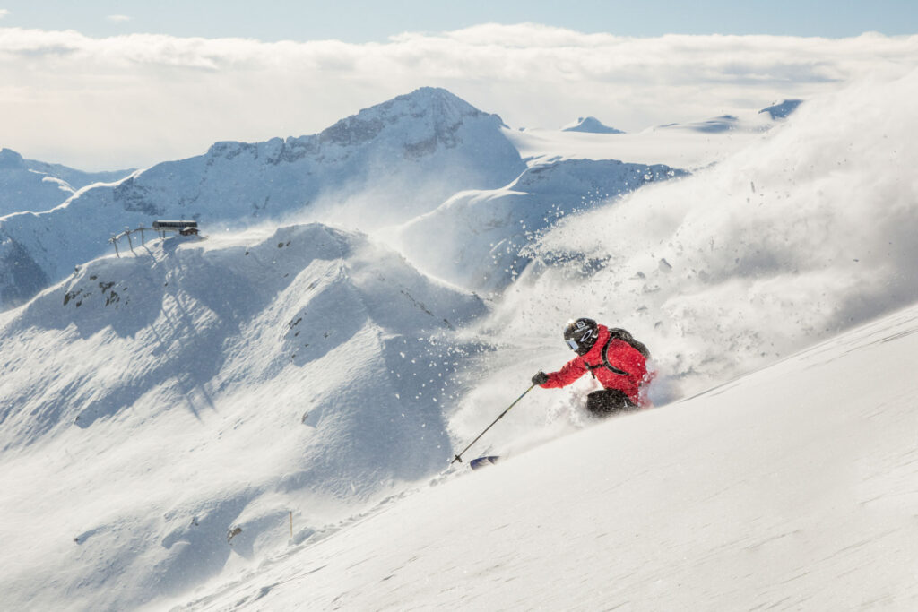 Skier in powder going down scenic run in Whistler Blackcomb