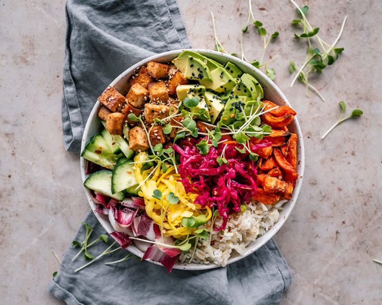 This beautiful Buddha bowl features pan roasted tofu, avocado, sweet potato, rice, vegetables and mixed seeds