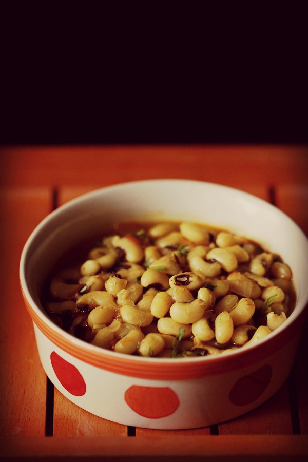 close up shot of lobia recipe in a dotted ceramic bowl on an orange tray. 