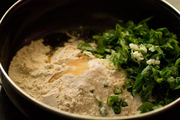 whole wheat flour, salt, methi leaves, green chilies, chopped garlic and oil in a bowl.