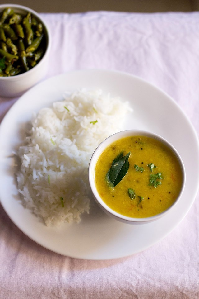 varan bhat served on a plate and bowl with a bowl of sabzi kept in the top left side.