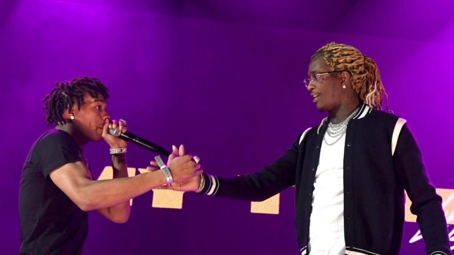 Lil baby & Young Thug shaking hands on stage during a performance.