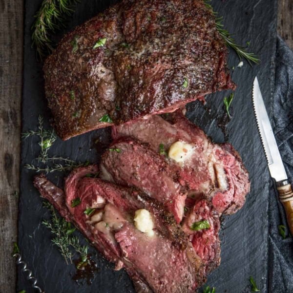 Boneless Smoked Prime Rib on a platter topped with horseradish butter