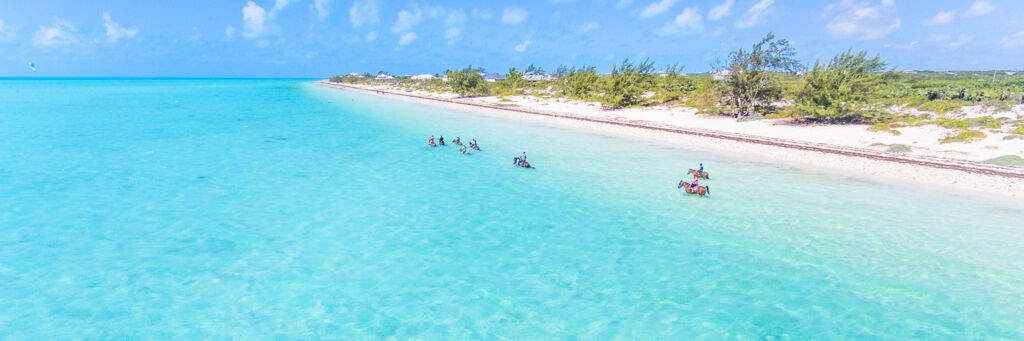 Horseback riding in the water at Long Bay Beach