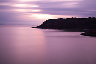 photography of mountain beside ocean under blue sky, gower