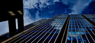 photo of skyscraper under white clouds