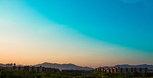 buildings in front of mountain, sky