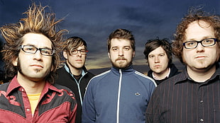 five men band members standing with mountain background