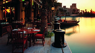 table near boat on river during sunset