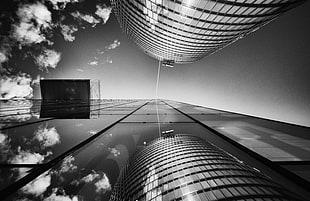 gray scale photo and worms eye view of two buildings