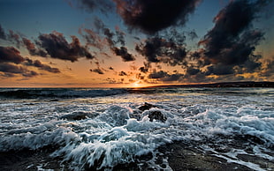 strong ocean waves hammering beach side during sunst