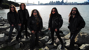 five men wearing sunglasses standing on rocks