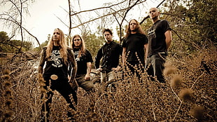 five man wearing black shirt standing beside tree